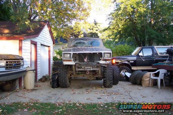 1978 Ford Bronco, front view, disassembled, with large tires, parked next to a black Bronco