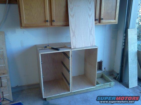 unfinished wooden cabinet boxes with drawer slides installed, under wall cabinets