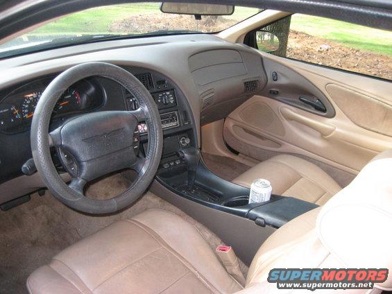 Tan leather interior of a 1997 Ford Thunderbird with a bird emblem on the steering wheel