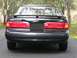 1997 Ford Thunderbird - Rear view of a black car with a spoiler and distinctive taillights. The 'Thunderbird LX' badge is visible.