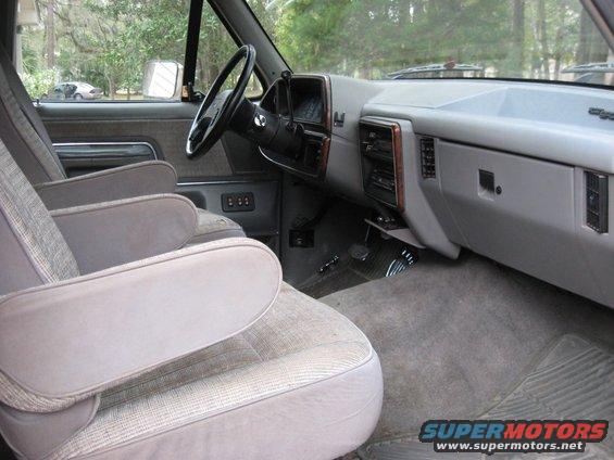 Interior of a 1987 Ford Bronco with cloth bucket seats, dashboard, and steering wheel
