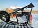 1973 Harley-Davidson Ultra - A black motorcycle frame is loaded into a snow-covered truck bed, alongside a tire and cardboard boxes.