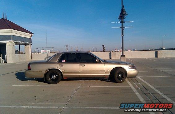 Gold 2000 Mercury Grand Marquis, side view, parked in a lot