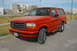 1995 Ford Bronco - This 1995 Ford Bronco is shown in a 3q-front view, parked on a paved surface with buildings in the background.