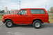 1995 Ford Bronco - A red Ford Bronco SUV is parked on a street, viewed from the side.