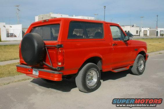 Red 1995 Ford Bronco rear view with spare tire mounted on the tailgate