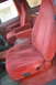 1995 Ford Bronco - The interior of the vehicle features red velour bucket seats with prominent armrests and power seat controls.