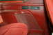 1995 Ford Bronco - Interior view of a red car door panel and seat, showing a storage compartment and buttons.
