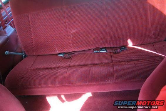 Red corduroy rear seat with seatbelts visible