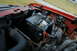 1995 Ford Bronco - The engine bay of a vehicle, a battery and various hoses and wiring.