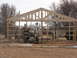 1995 Ford Bronco - A construction site shows a wooden building frame under construction, with two vehicles and lumber in the foreground.
