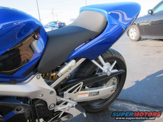 Blue motorcycle rear section with black seat and silver swingarm