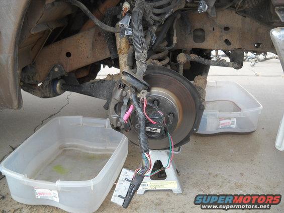 Front wheel assembly with brake rotor and wiring harness on jack stand