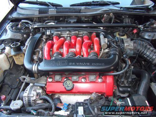 Engine bay with SHO 24 valve DOHC engine, red valve covers, and black intake manifold