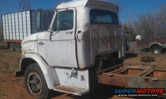 White 1961 Ford F-series truck cab, rusty frame, parked next to a white trailer