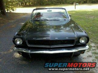 Black 1965 Ford Mustang convertible, front view, chrome bumper, grille, headlights, hood emblem
