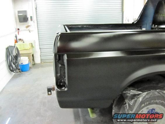 Rear quarter panel of a Ford truck being prepped for paint. Tail light area is exposed