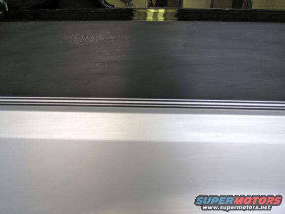 Silver SUV rear quarter panel with black trim and Supermotors.net watermark