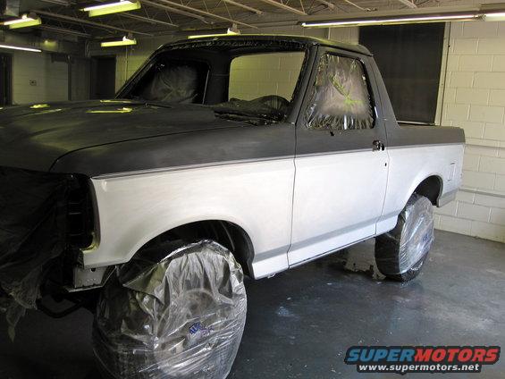 1992 Ford Bronco in a paint booth, two-tone gray and white