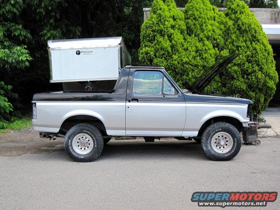 1992 Ford Bronco side profile with a cargo box mounted on the roof and hood open