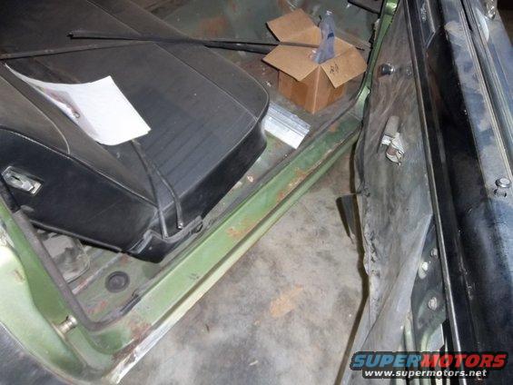 Inside of a car, showing the passenger seat and door panel. A small cardboard box is on the floor