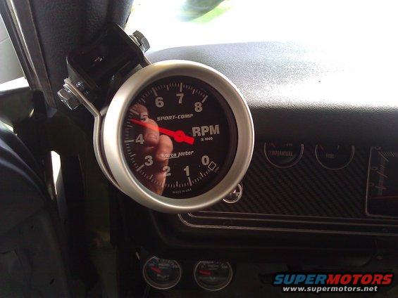Tachometer and dashboard gauges in a car interior, with a red needle pointing to 4.5