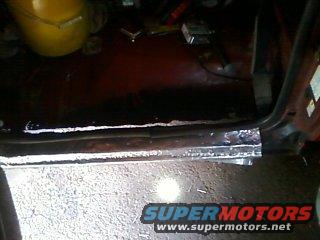 Close-up of a rusted door sill with SuperMotors logo