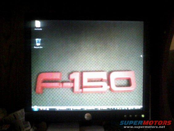 Computer monitor displaying a red F-150 emblem on a textured background