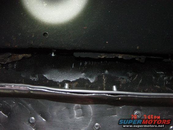 Underside of vehicle showing rust and metal repairs