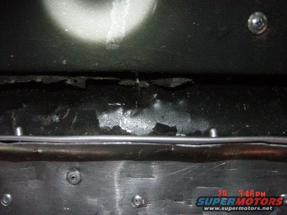 Close-up of a corroded metal panel with visible rivets and a timestamp