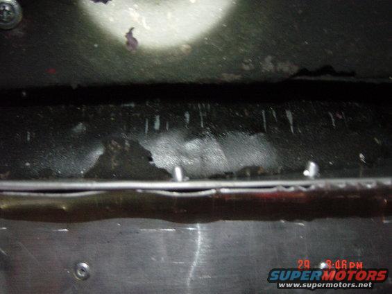 underbody view showing fluid leaks and some metal components