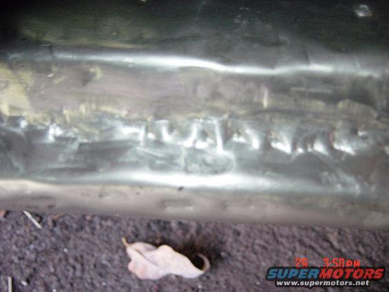Close-up of a welded metal panel with visible weld marks
