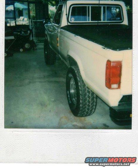 Cream-colored 1999 Ford Ranger pickup truck, rear 3/4 view, parked indoors