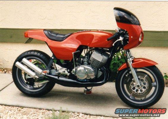 Red cafe racer motorcycle with dual exhaust pipes and a small fairing