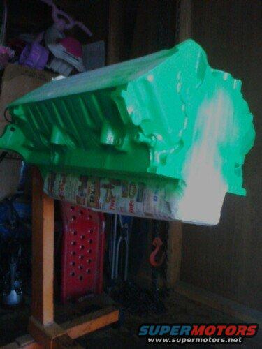 Green engine block on an orange stand, partially painted white