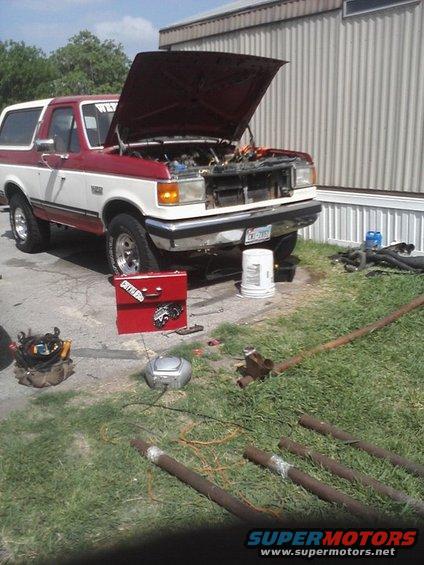 1989 Ford Bronco with hood open, red and white exterior, parked outside