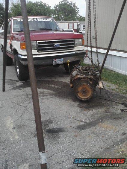 1987 Ford F-Series pickup truck with an engine being lowered next to it