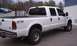 2002 Ford F-250 - This white 2002 Ford F-250 Super Duty pickup truck is seen from a three-quarter front angle, parked in a lot.