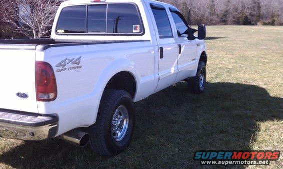 White 2002 Ford F-250 pickup truck, rear 3/4 view, parked on grass