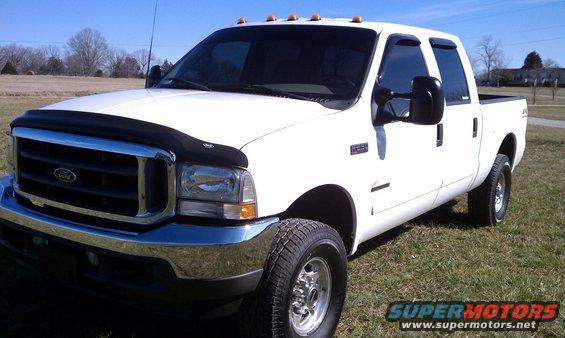 White 2002 Ford F-250 pickup truck parked on grass