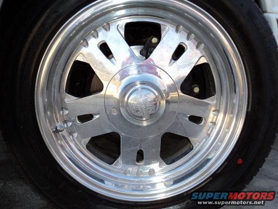 Close-up of a shiny chrome wheel with a multi-spoke design and a center cap with an emblem