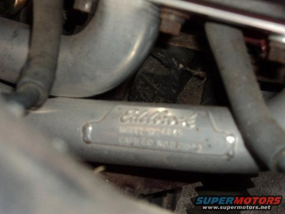 Close-up of an Eldelbrock engine part with model and catalog numbers stamped