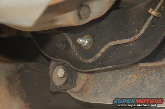 Close-up of a vehicle's undercarriage, showing suspension components and wiring