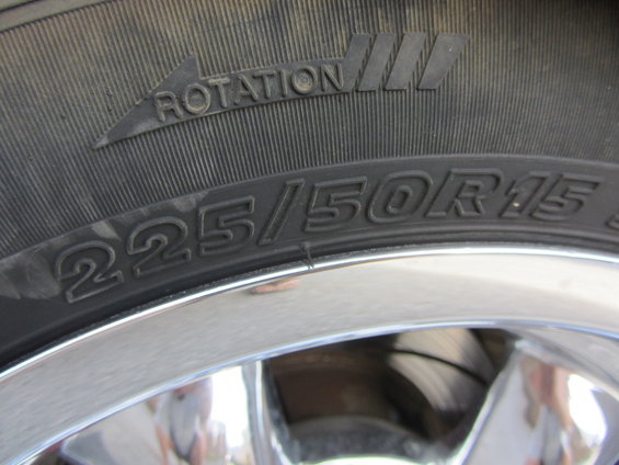 Close-up of a tire with size 225/50R15 and rotation arrow