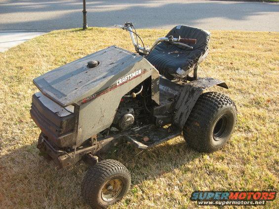 Craftsman riding mower with a torn seat and dirty body, parked on dry grass