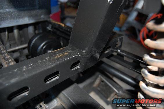 Black metal frame section with oval cutouts and coil spring