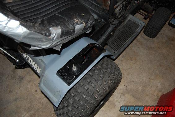 Close-up of a Craftsman lawn tractor seat and gray fender with a knobby tire