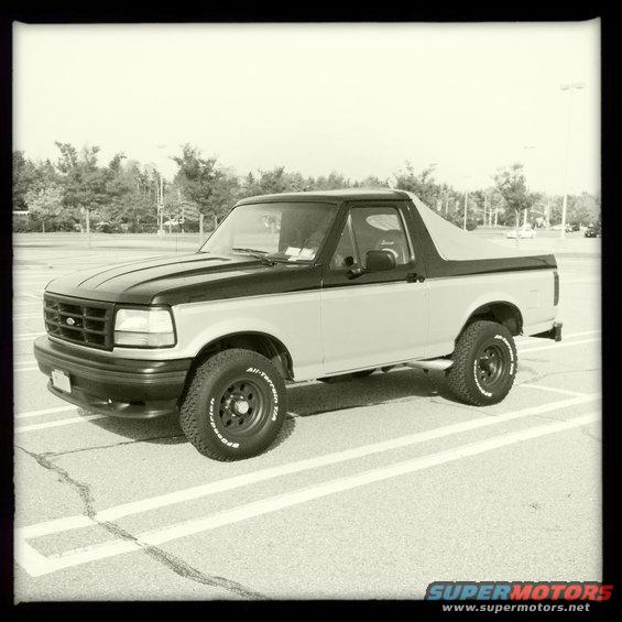 Two-tone 1992 Ford Bronco parked in a lot, side view