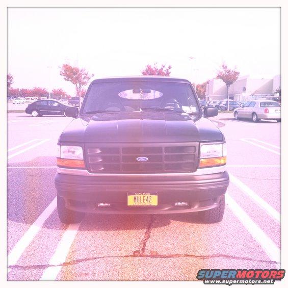 Front view of a dark 1992 Ford Bronco parked in a lot. License plate reads MULE42