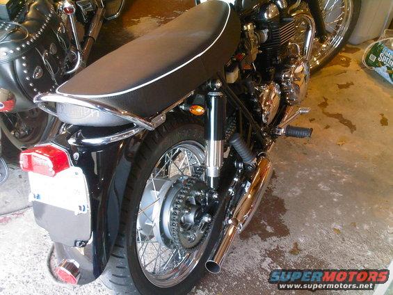 chrome grab rail, vintage tail light and plate holder. pipes are Norman Hyde Togas from England. great sound. seat is off a Scrambler, i liked the white piping. got a gold paint marker and filled in the Triumph logo.
